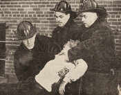 Firefighters carry an unidentified person away from the Phillips Garment Co. factory fire, January 20, 1950. Globe and Mail.